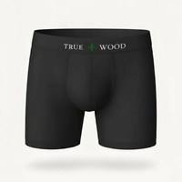 White men's boxer briefs with the words 'TRUE WOOD' in black and a green leaf icon on the waistband, styled in a clean serif font, displayed against a light background.