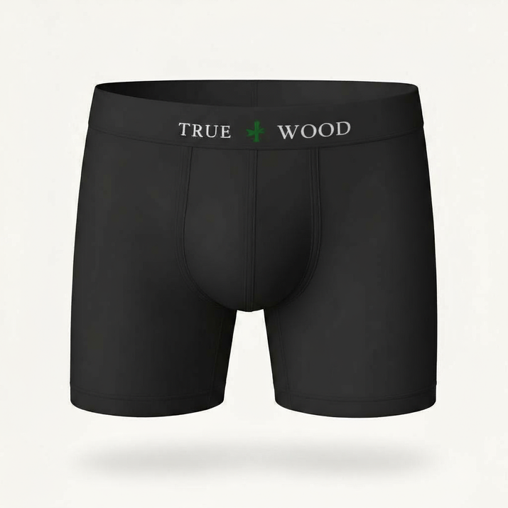 White men's boxer briefs with the words 'TRUE WOOD' in black and a green leaf icon on the waistband, styled in a clean serif font, displayed against a light background.