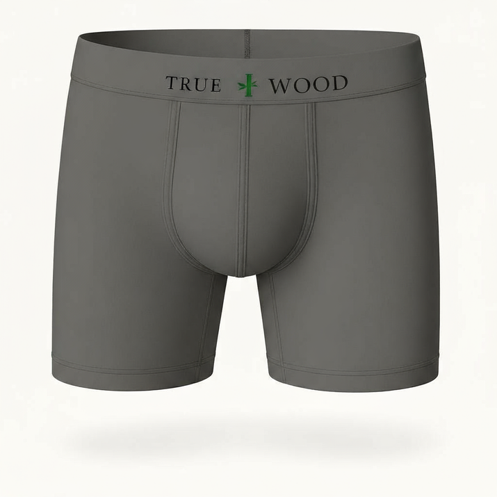 Gray men's boxer briefs with the words 'TRUE WOOD' in black and a green leaf icon on the waistband, styled in a clean serif font, displayed against a light background.